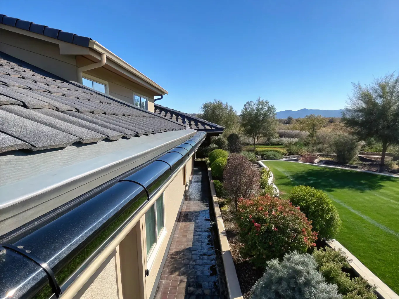 A residential property with clean gutters and downspouts, emphasizing the importance of gutter cleaning to prevent water damage.